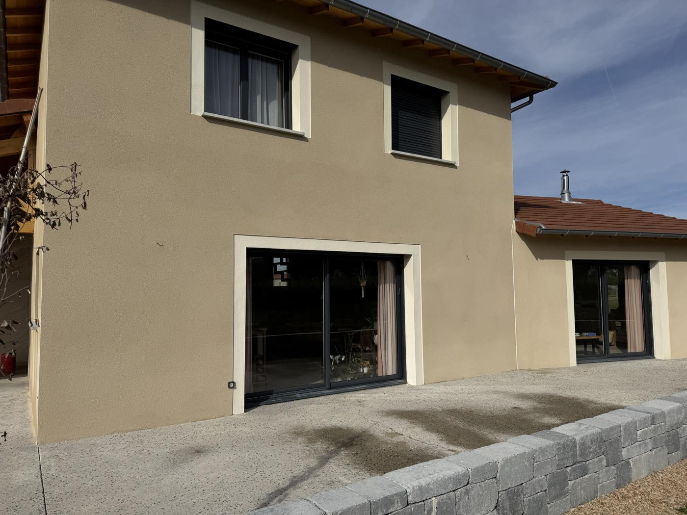 Maison à l'enduit beige, encadrements de baies en teinte claire